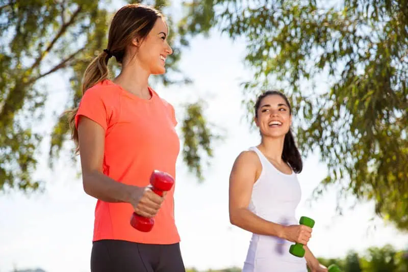Two Women Walking with Hand Weights